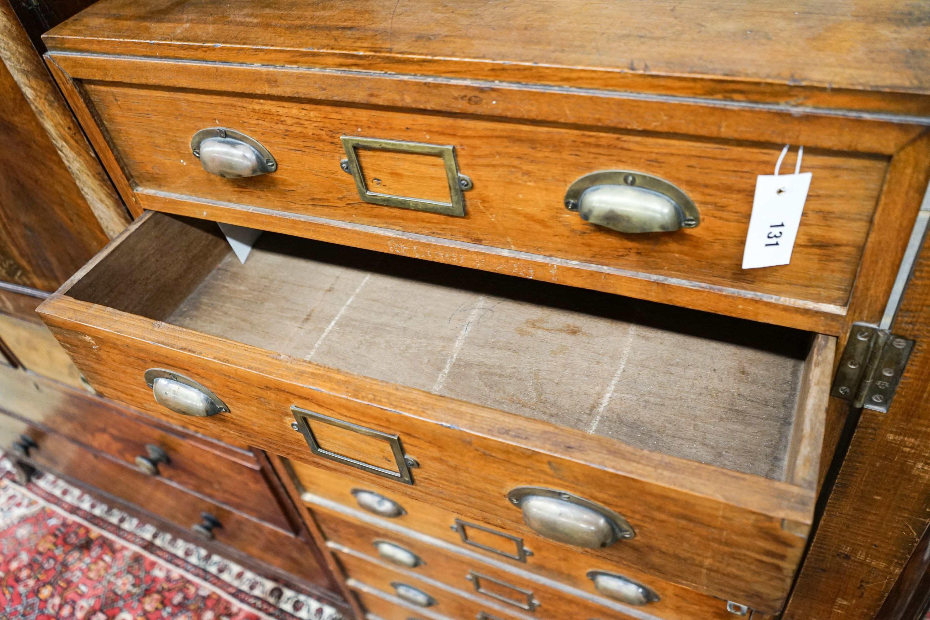 An early 20th century teak nine drawer filing chest with single locking bar, width 70cm, depth 63cm, height 142cm